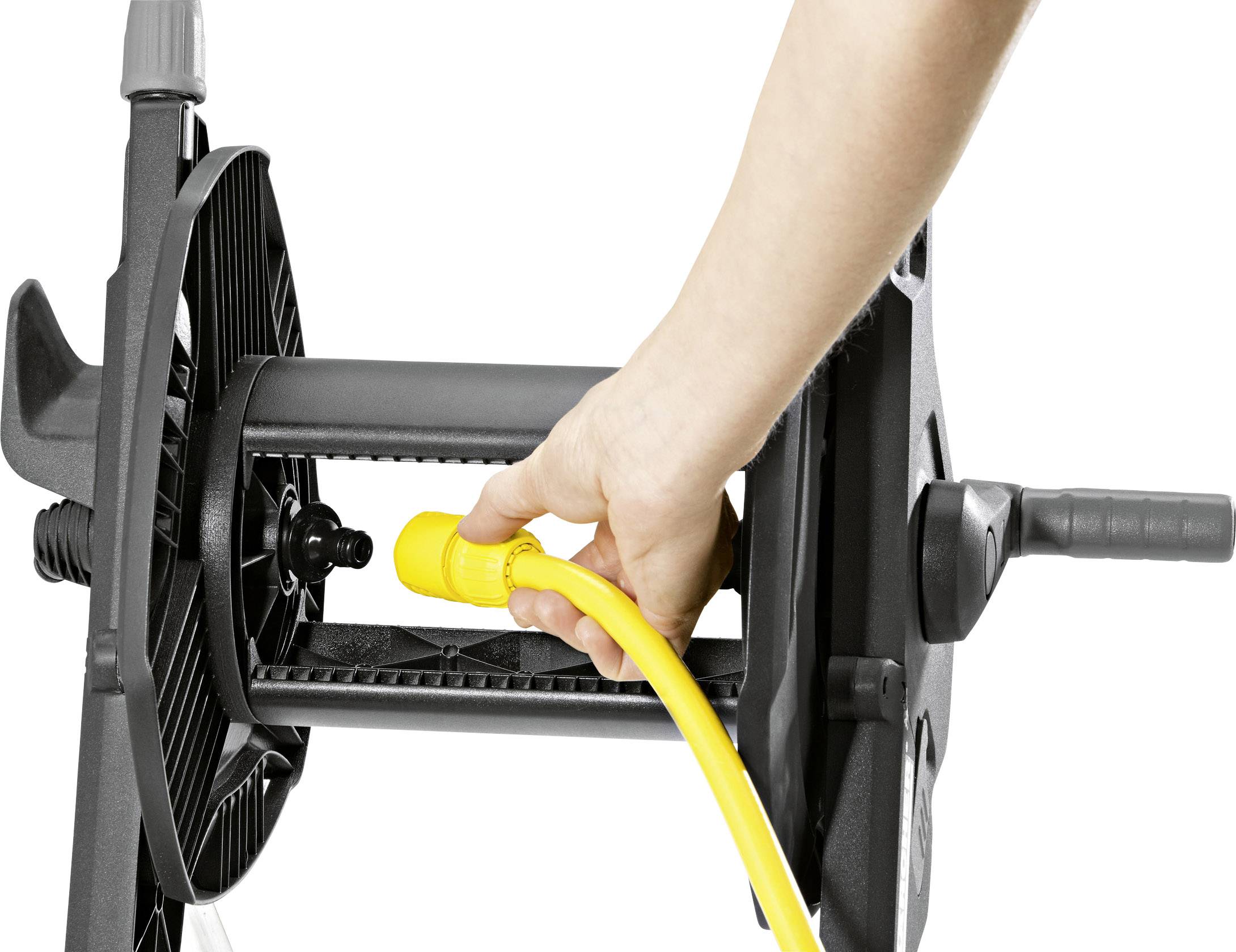 Osoba wyciąga żółty kabel z czarnej szpuli kablowej.