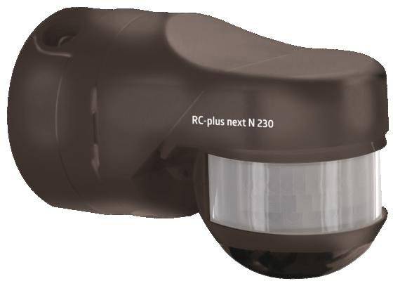 Brązowy czujnik ruchu z napisem 'RC-plus next N 230' na boku. Nadaje się do stosowania na zewnątrz do wykrywania ruchu.