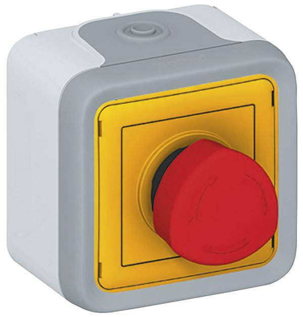 Czerwony przycisk bezpieczeństwa na prostokątnej, szaro-żółtej obudowie. Przycisk służy do natychmiastowego wyłączenia maszyn.