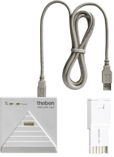 Urządzenie programujące 'theben OBELISK top2' z kablem USB i adapterem do podłączania urządzeń do programowania zegarów sterujących.