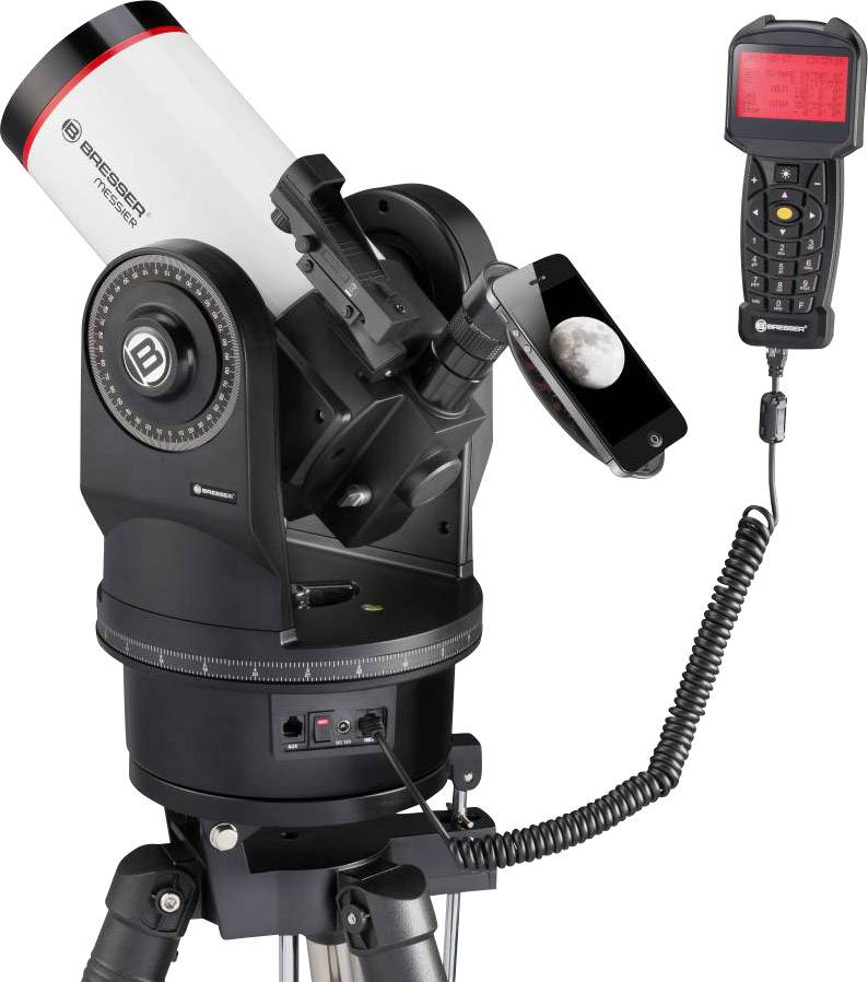 Teleskop na statywie z zamontowanym smartfonem wyświetlającym zdjęcie Księżyca. Obok teleskopu wisi pilot z czerwonym wyświetlaczem.