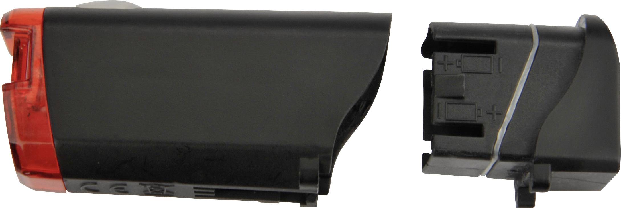 Czarne i czerwone tylne światło rowerowe, rozłożone na dwie osobne części. Po prawej: komora baterii.