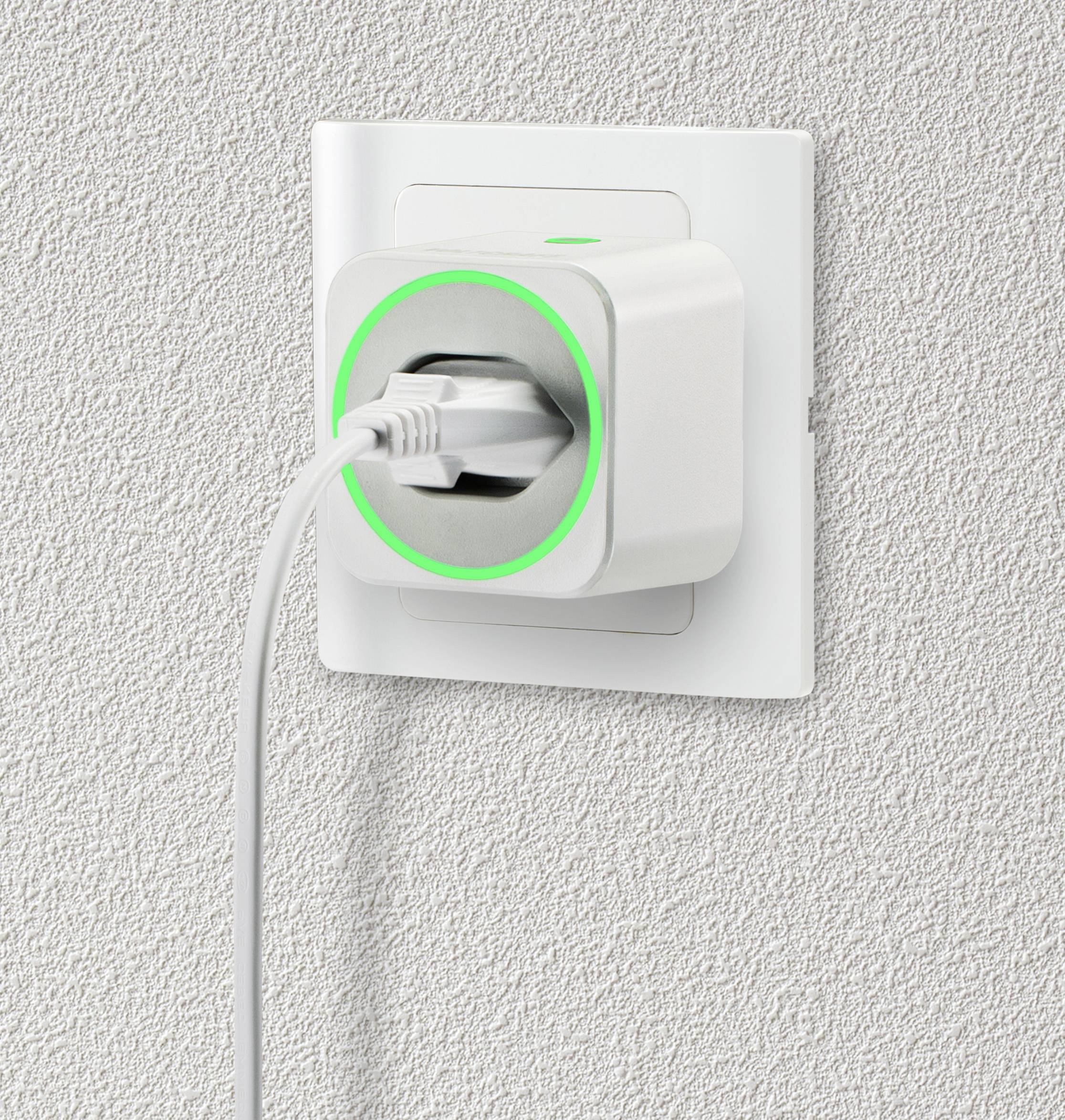 Gniazdko elektryczne na ścianie z wtyczką włożoną do środka. Gniazdko posiada świecący się zielony pierścień, który prawdopodobnie sygnalizuje jakąś funkcję.