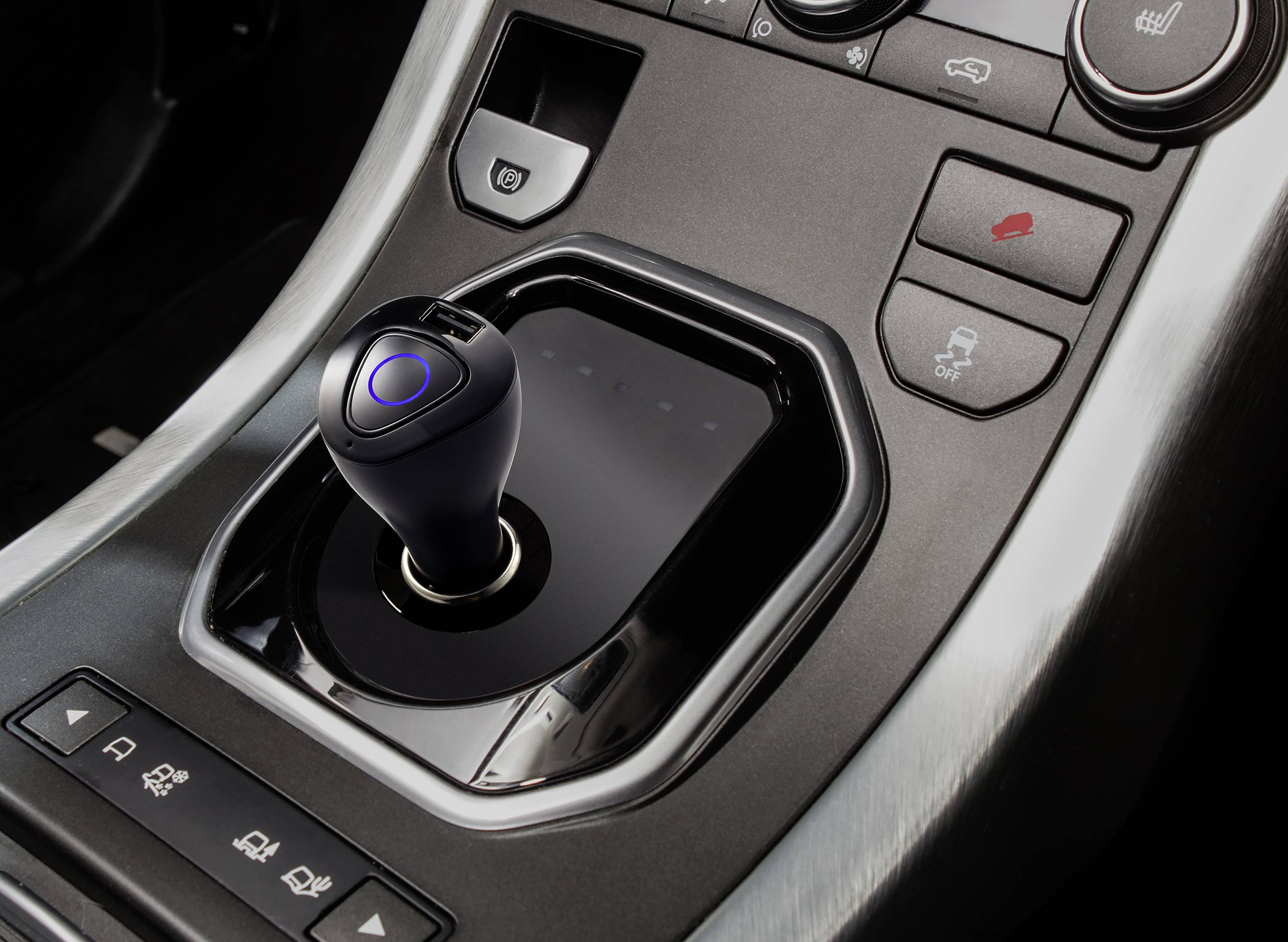 Dźwignia zmiany biegów samochodu z wieloma przyciskami funkcyjnymi na konsoli środkowej, w tym przyciski do parkowania i podgrzewania siedzeń.