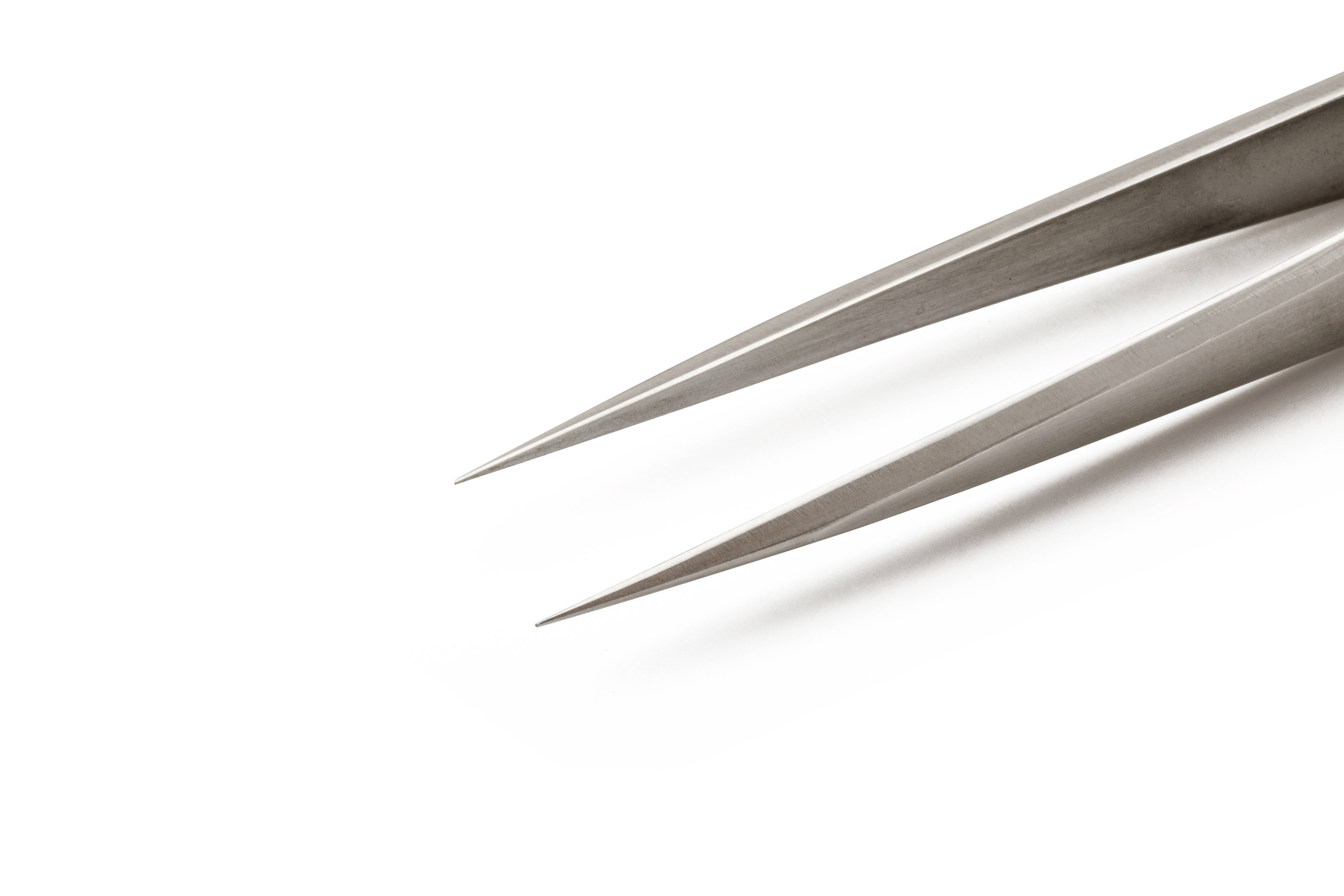 Zbliżenie metalowych pęset, których oba czubki są skierowane w prawo i lekko od siebie oddalone.