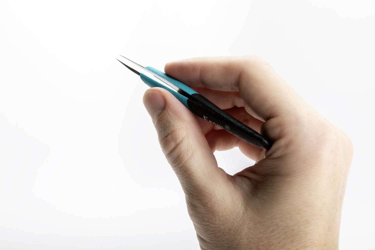 Dłoń trzyma małą, spiczastą pincetę na białym tle, gotową do precyzyjnych prac lub projektów majsterkowania.