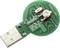 Okrągły dongle USB z zieloną płytką drukowaną i elementami elektronicznymi, w tym białym przełącznikiem i kilkoma opornikami.