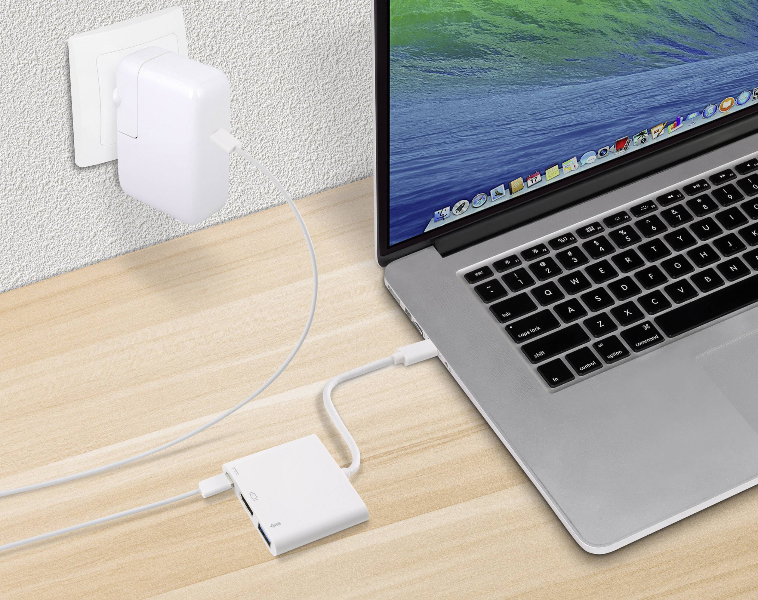 Laptop jest ładowany za pomocą ładowarki podłączonej do gniazdka elektrycznego. Kabel przebiega przez adapter do laptopa.