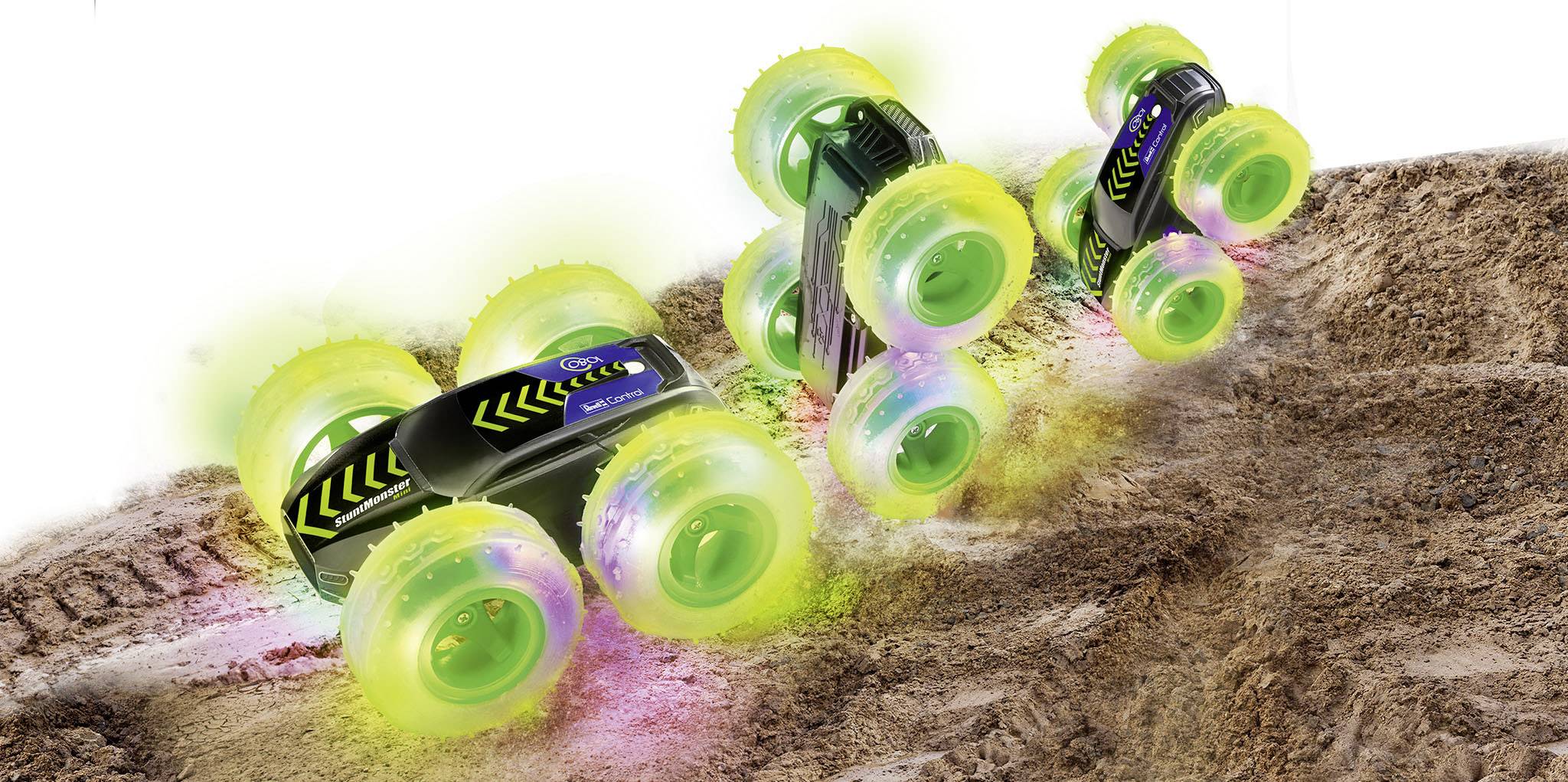 Zabawkowy samochód z świecącymi zielonymi kołami porusza się i obraca po nierównym, ziemistym terenie, demonstrując swoją zdolność do jazdy w trudnym terenie.