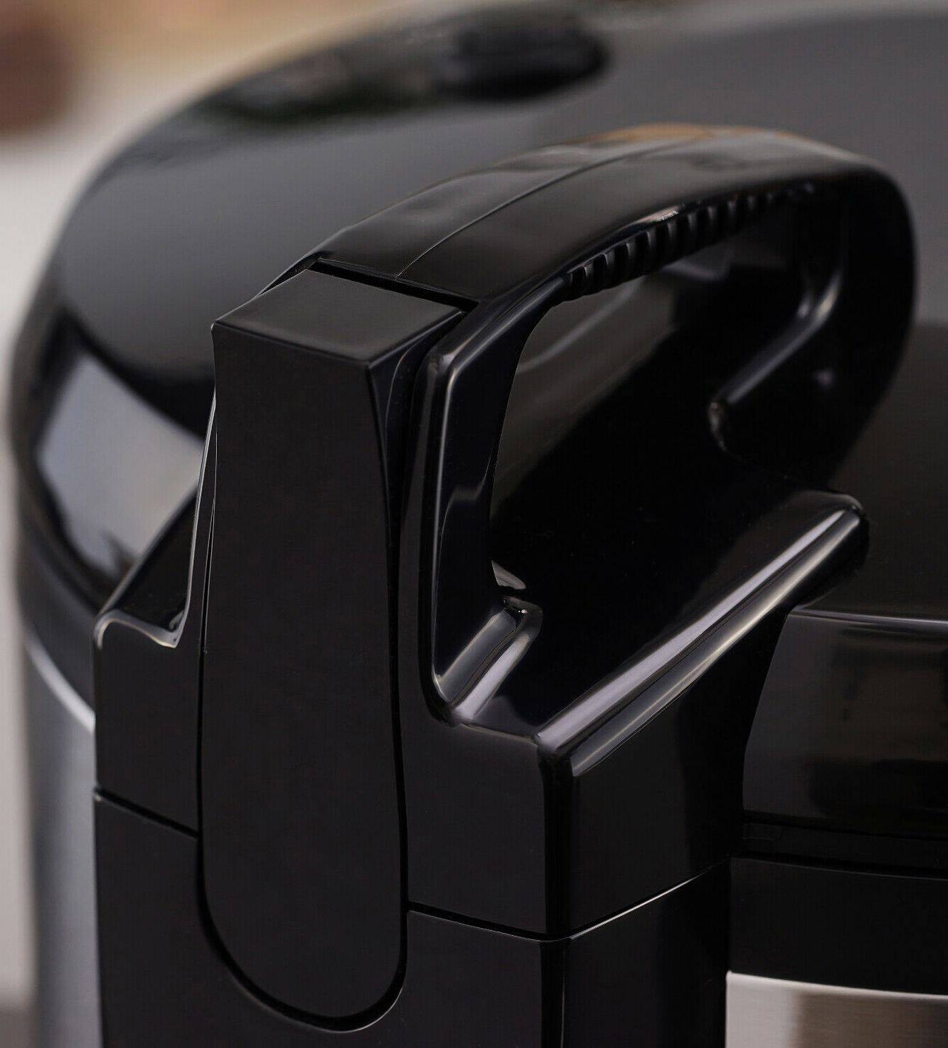 Czarny uchwyt nowoczesnego urządzenia kuchennego, prawdopodobnie szybkowaru, o błyszczącej powierzchni, prezentuje solidną budowę.