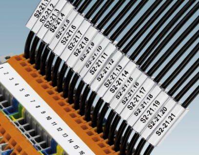 Kilka czarnych kabli jest podłączonych do pomarańczowego złącza. Każdy kabel jest oznaczony etykietą w stylu 'S2:21.12'.