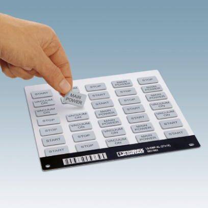 Dłoń wskazuje na tablicę z wieloma szarymi przyciskami. Przyciski są oznaczone napisami takimi jak 'START', 'STOP' i 'MAIN POWER'.