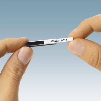 Dwie ręce trzymają srebrny i czarny kompaktowy przedmiot na niebieskim tle.