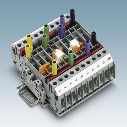 Listwy zaciskowe na płycie montażowej z kolorowymi złączami do połączeń elektrycznych w szafie sterowniczej.