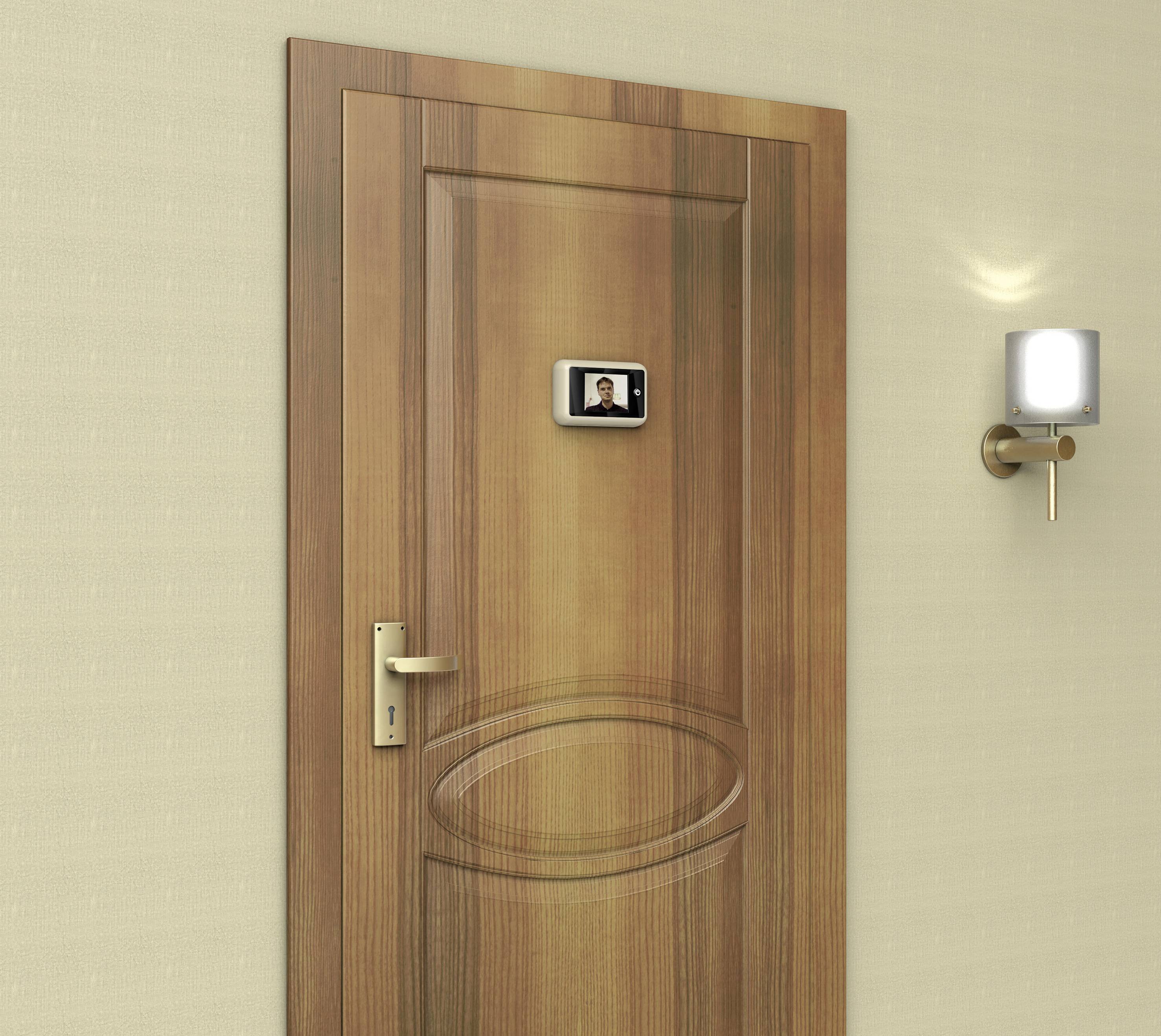 Drewniane drzwi z cyfrowym wizjerem pośrodku, wyświetlającym małe zdjęcie. Po prawej stronie na ścianie wisi świecąca lampa ścienna.