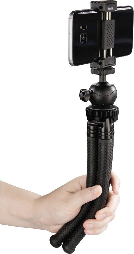 Ręka trzyma elastyczny statyw z zamocowanym smartfonem. Statyw posiada giętkie nogi umożliwiające ustawienie w różnych pozycjach.