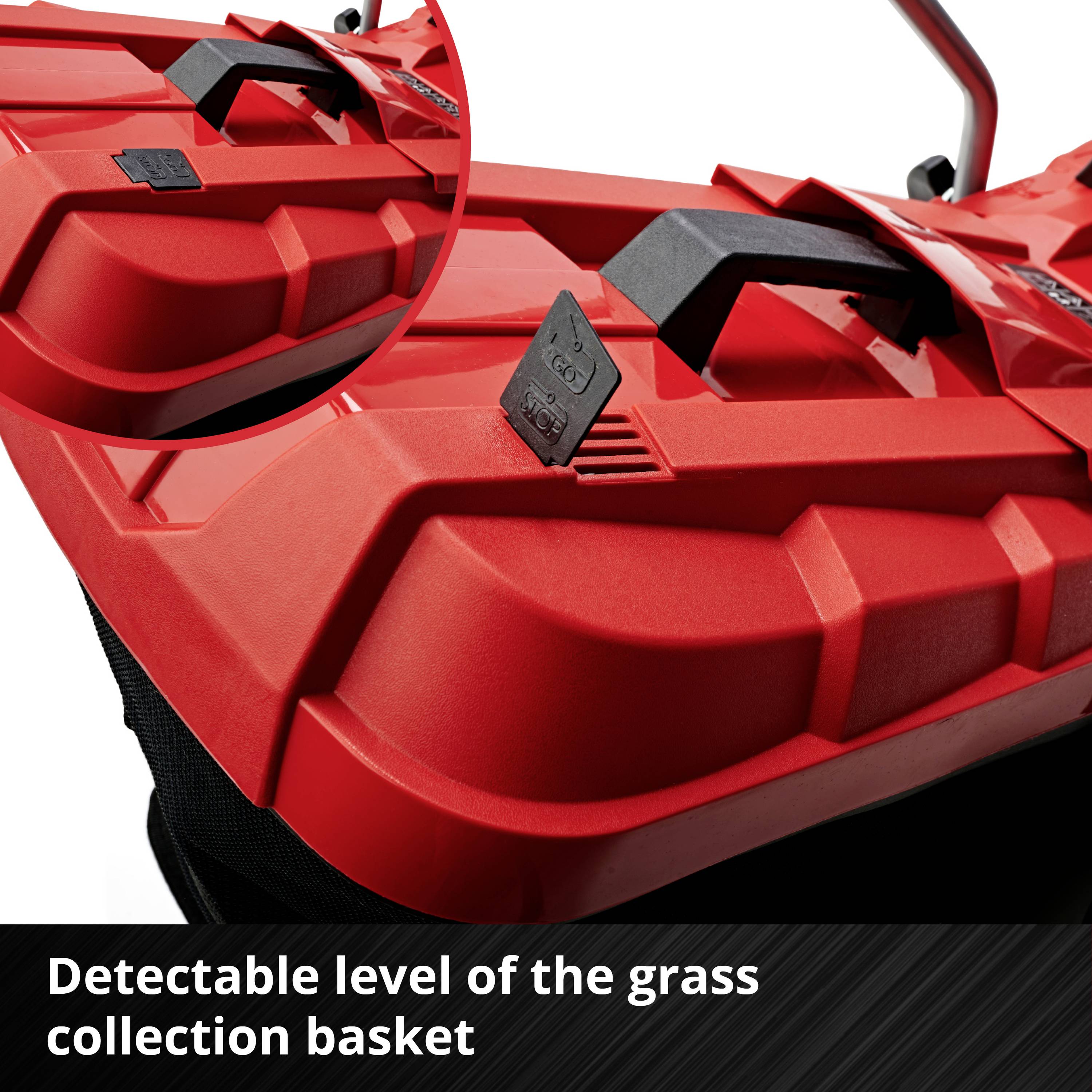Czerwony kosz na trawę z widocznym wskaźnikiem poziomu napełnienia na kosiarce. Uchwyt jest czarny i dobrze widoczny.