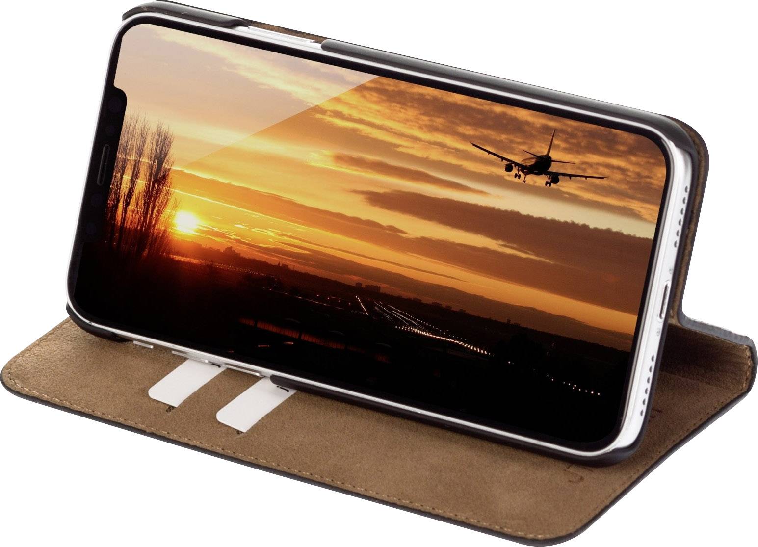 Smartfon w etui, pokazujący zdjęcie samolotu lądującego o zachodzie słońca.