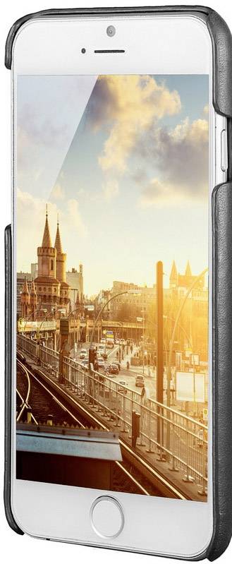 Smartfon z wyświetloną panoramą miasta, torami kolejowymi i historycznym budynkiem o zachodzie słońca.