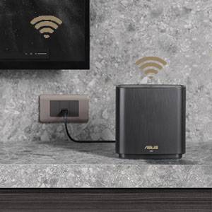 Router sieciowy ASUS stoi na szarej powierzchni obok gniazdka ściennego. Oba urządzenia wyświetlają sygnały Wi-Fi.