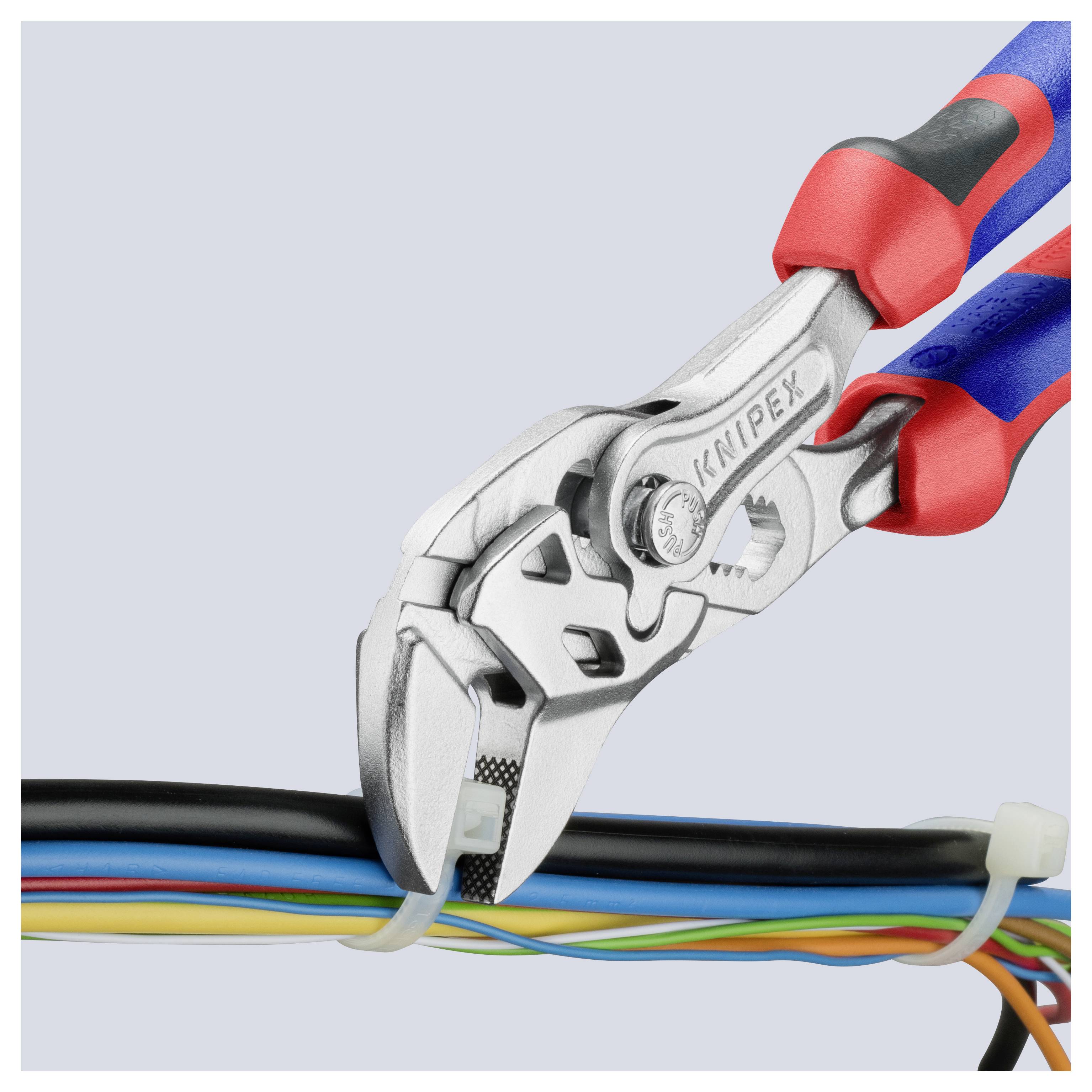 Narzędzie ręczne przecina plastikowy opasacz wiążący wiele kolorowych przewodów, prezentując swoją funkcję cięcia i projekt uchwytu.