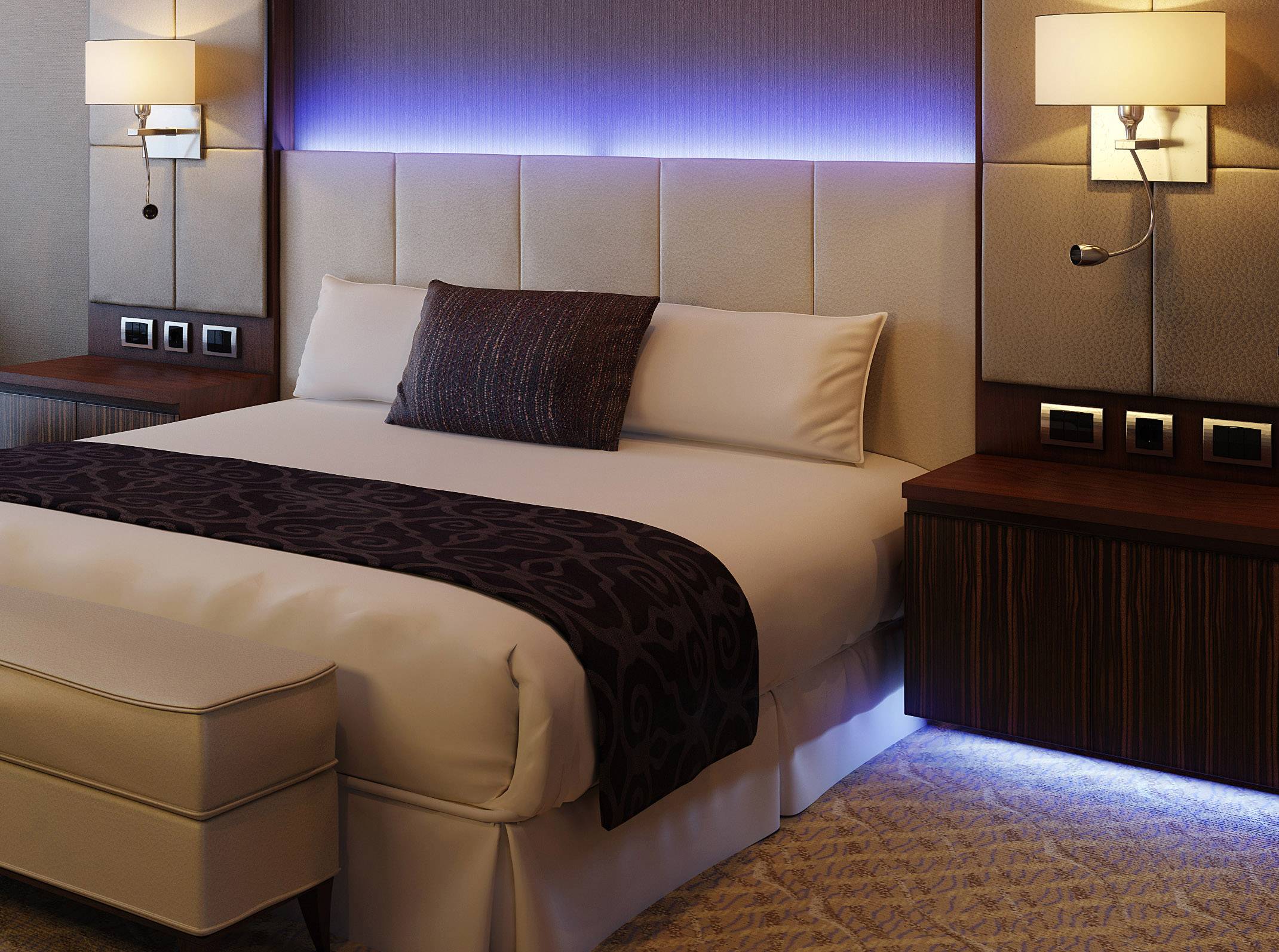 Nowoczesny pokój hotelowy z dużym podwójnym łóżkiem, miękkimi poduszkami i stylowym oświetleniem.