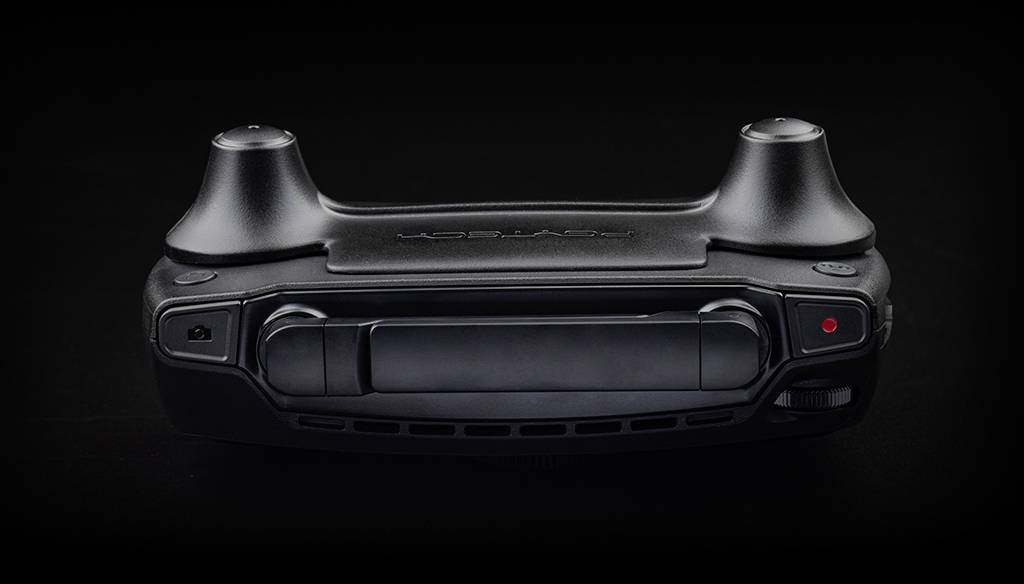 Czarny, kompaktowy kontroler ręczny z dwoma drążkami sterującymi i centralnym przyciskiem jest przedstawiony na czarnym tle.