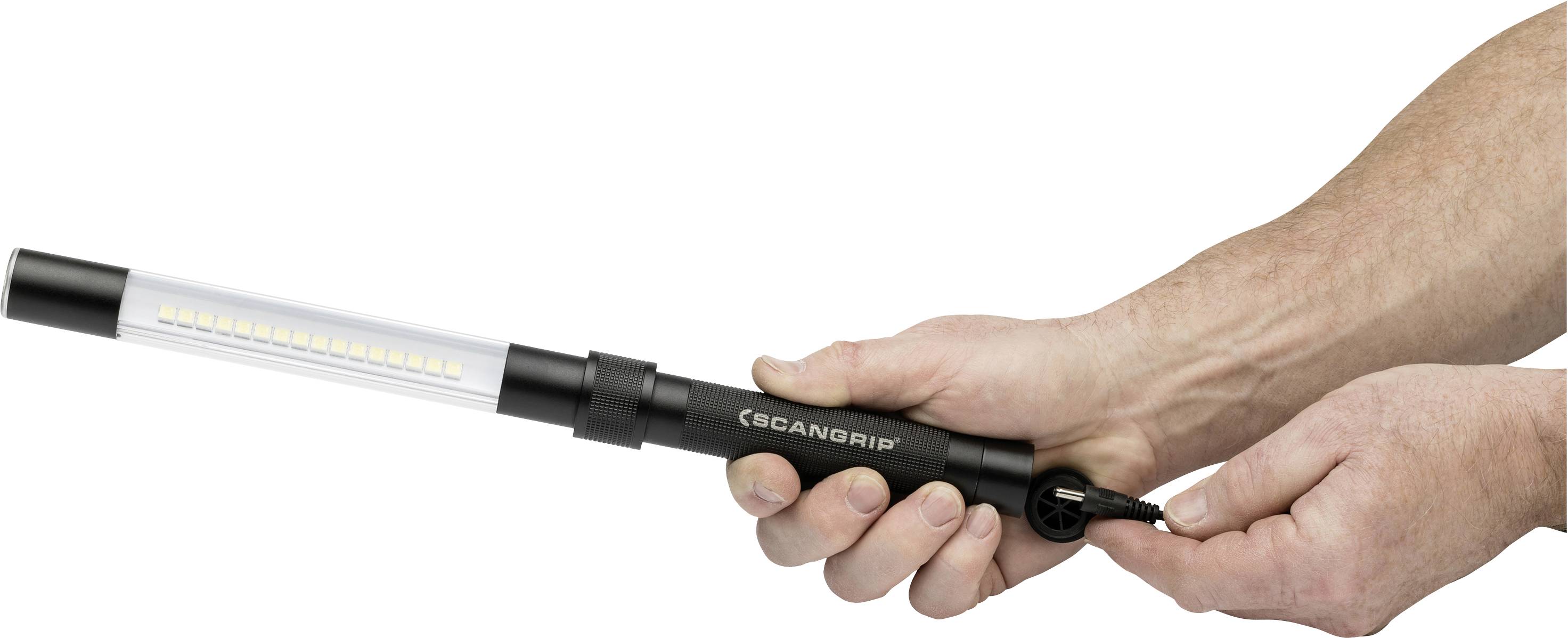 Dwie ręce trzymają prętową lampę roboczą LED, podczas gdy wtyczka jest wkładana do gniazda.