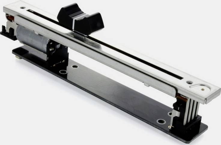 Srebrny, liniowy regulator przesuwny z czarnym przyciskiem. Służy do precyzyjnego sterowania urządzeniami lub maszynami.