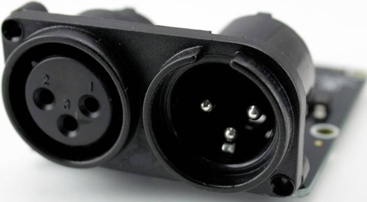 Czarna wtyczka XLR z dwoma stykami, zamontowana na płytce elektronicznej, przeznaczona do połączeń audio.