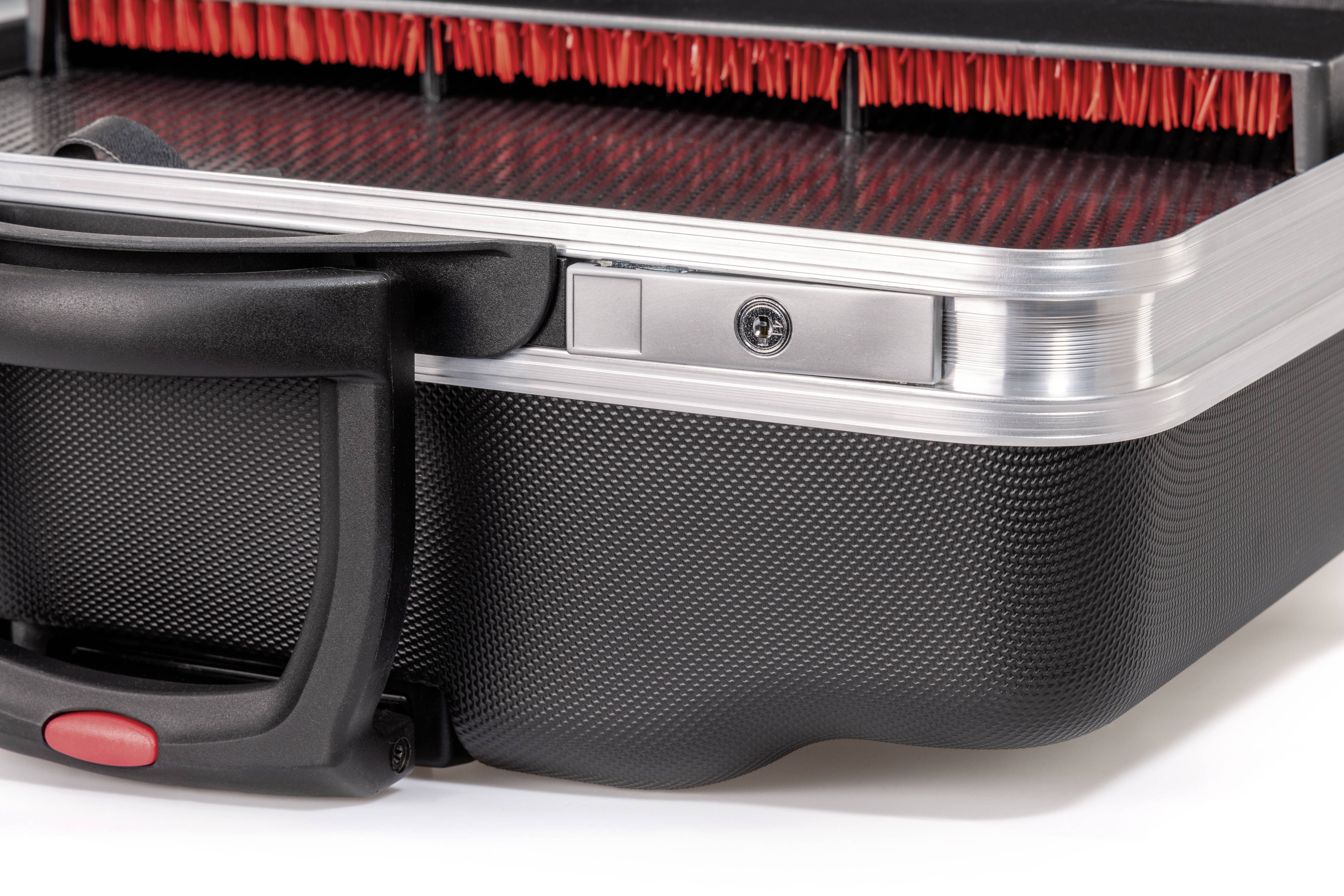 Zbliżenie walizki twardej z czerwoną podszewką wewnętrzną i czarną rączką. Fotografia przedstawia szczegółowe ujęcie materiału i struktury.