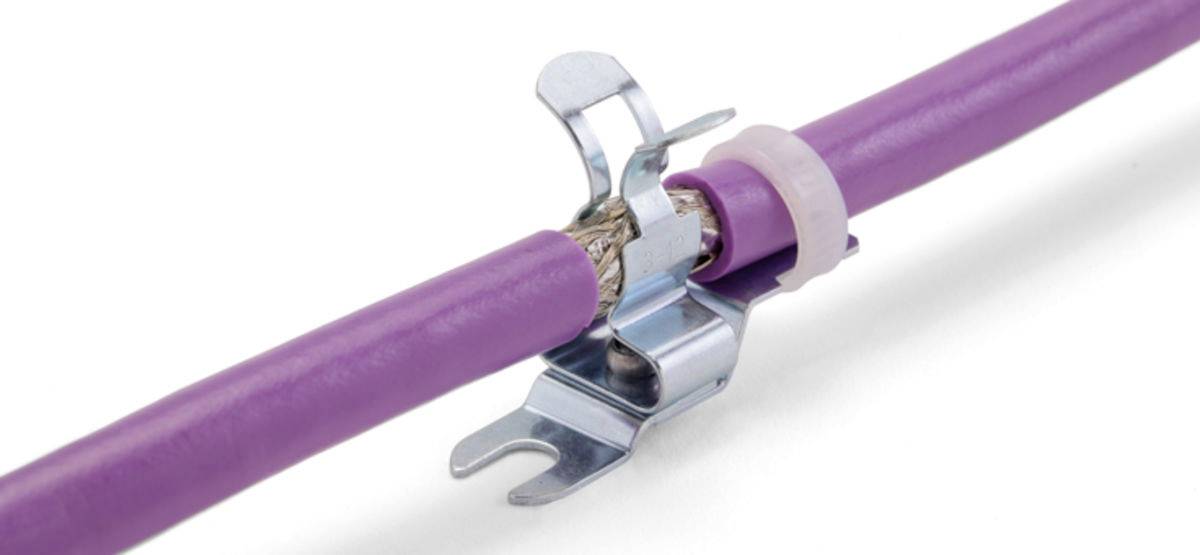 Fioletowy kabel połączony z metalowym zaciskiem pokazuje, jak można zabezpieczyć przewody wewnątrz urządzenia.