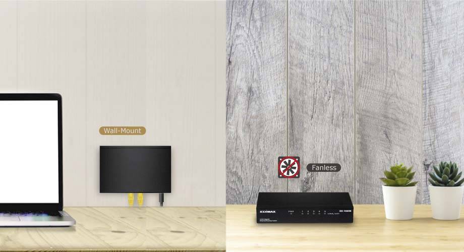 Pulpit z laptopem po lewej stronie przedstawia zamontowany na ścianie router i pozbawiony wentylatora switch sieciowy po prawej stronie, obok których stoją dwie małe rośliny.