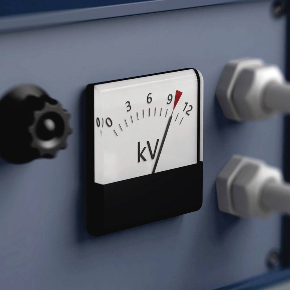 Analogowy miernik napięcia wskazuje około 9 kV. Po lewej stronie widoczny jest czarny pokrętło, po prawej zaś dwa srebrne złącza.
