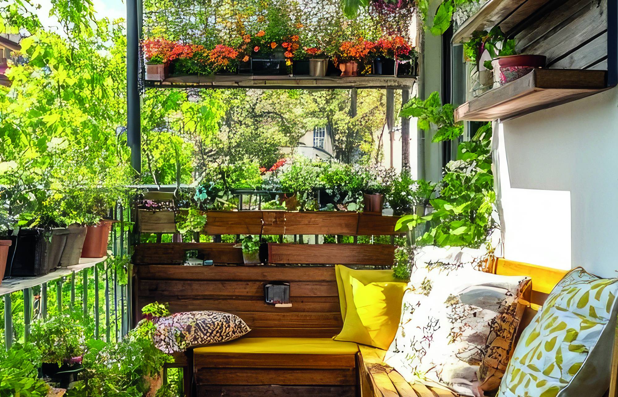 Oświetlony słońcem balkon ogrodowy z drewnianą ławką, żółtymi poduszkami, roślinami w doniczkach i wiszącymi kwiatami z widokiem na zieleń.