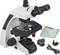 Białoczarny mikroskop z akcesoriami, takimi jak obiektywy, przewód zasilający i adapter. Nadaje się do badań naukowych.