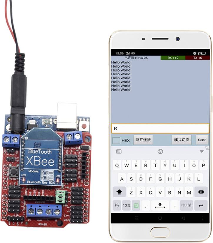 Smartfon wyświetla aplikację z wiadomością 'Hello World!'. Obok znajduje się płytka drukowana z modułem Bluetooth, połączona przewodami.