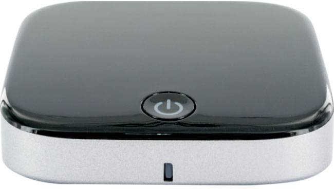 Czarno-srebrowy, kwadratowy router z zaokrąglonymi rogami i centralnym przyciskiem włączania/wyłączania na górnej powierzchni.