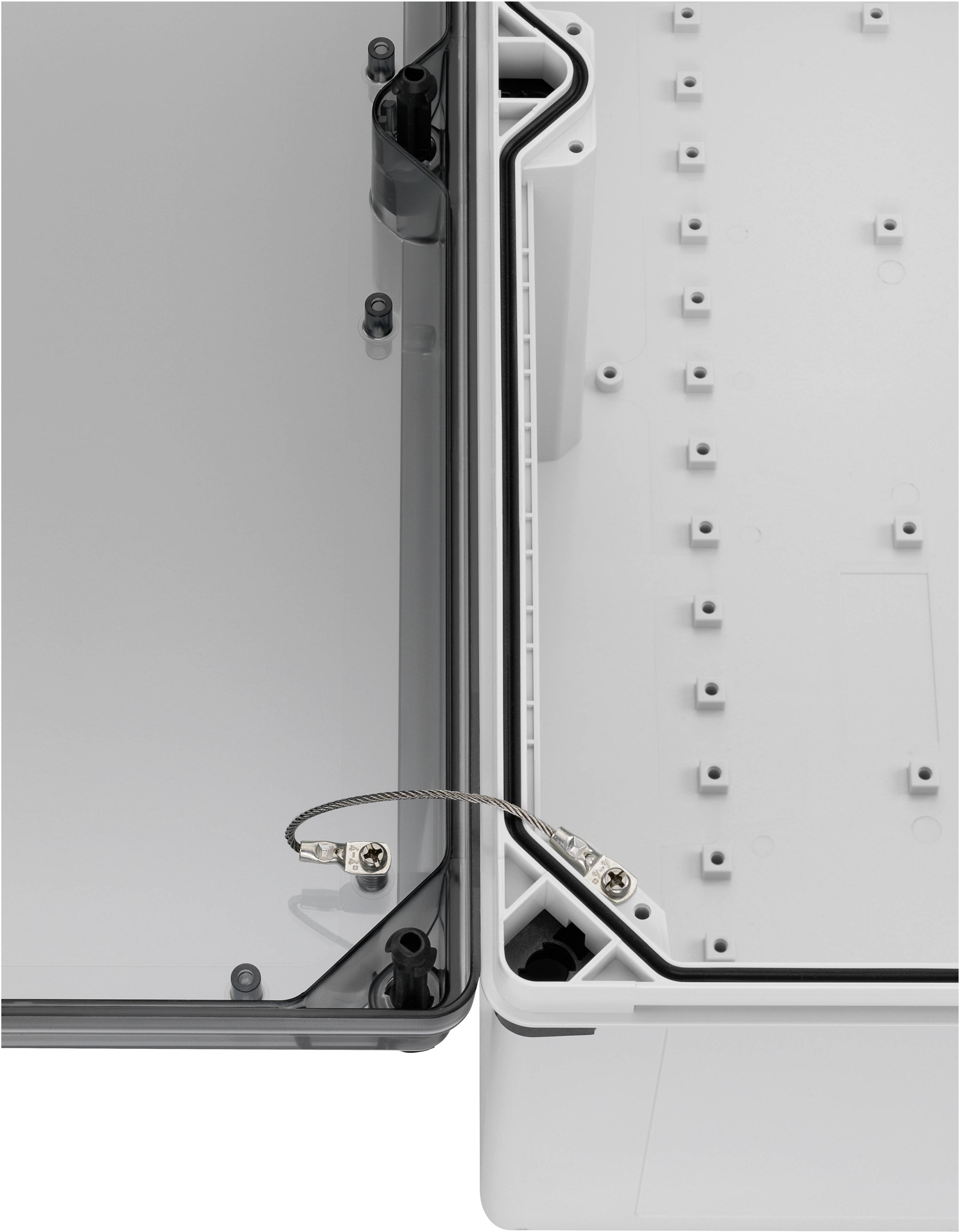 Otwarta obudowa elektryczna z przezroczystym pokrywą po lewej stronie. Kabel uziemiający łączy stronę pokrywy z dnem obudowy.