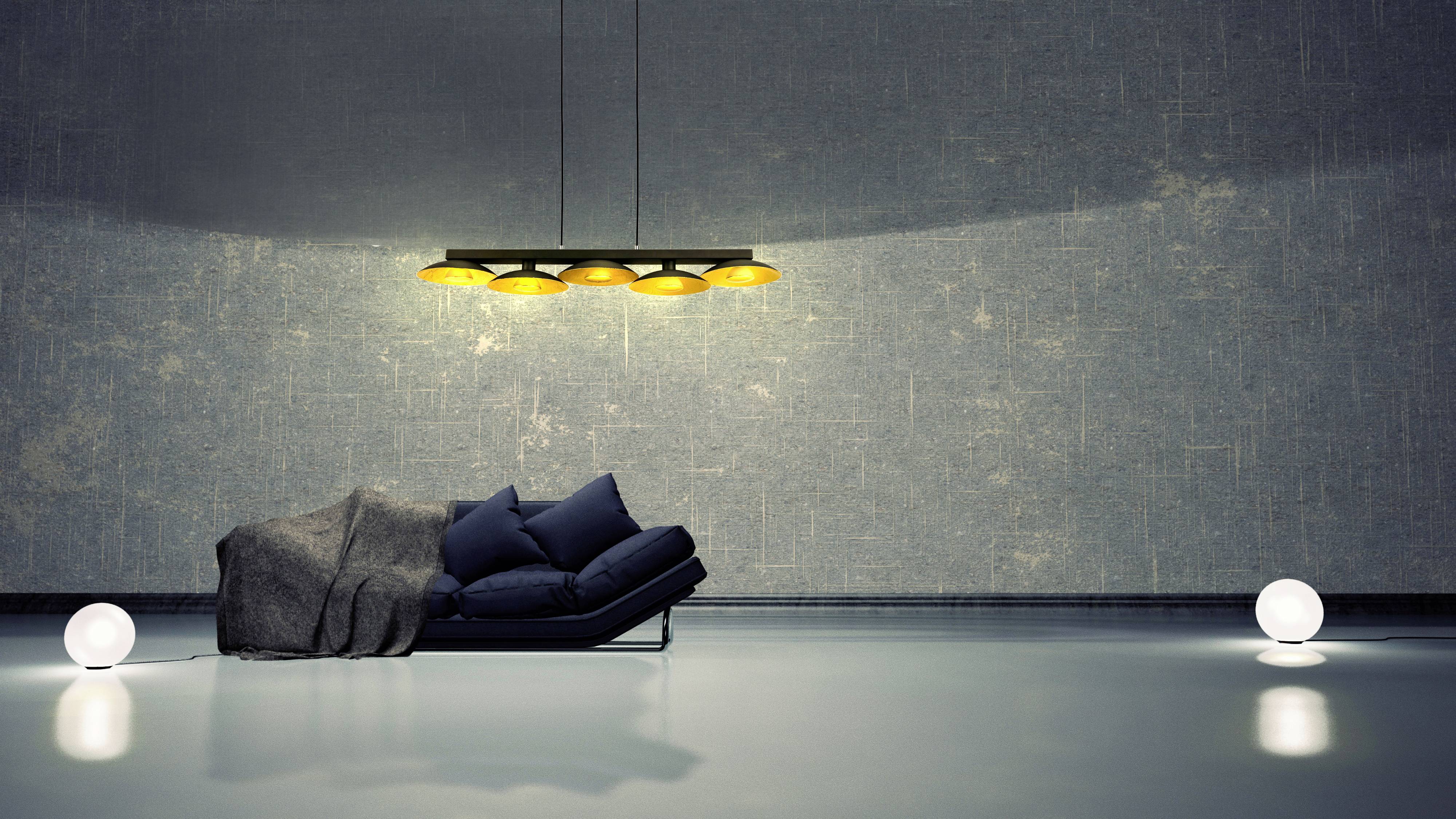 Elegancki salon z ciemnoniebieską sofą, szarym kocem i stylową lampą sufitową. Dwie świecące kule na podłodze.
