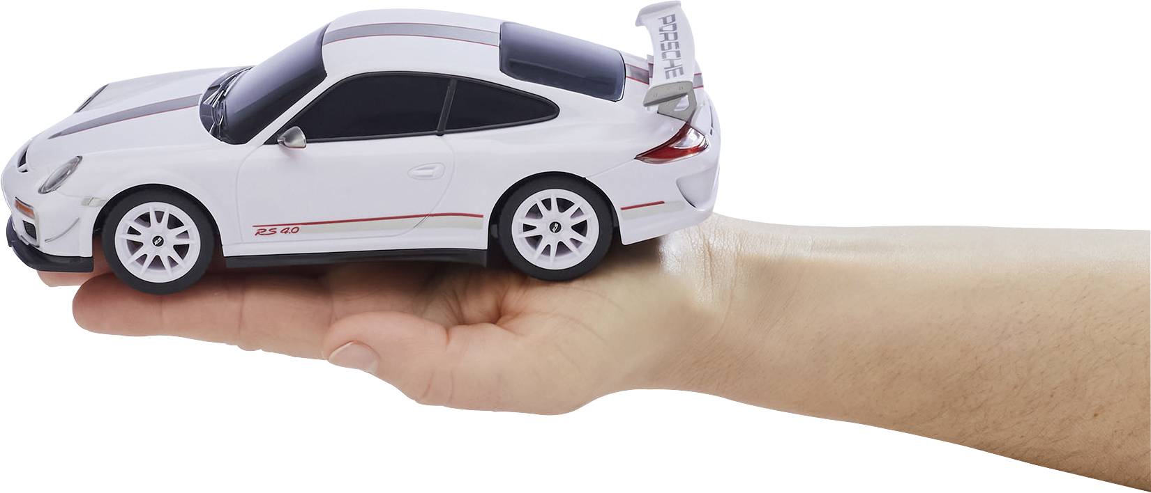 Dłoń trzyma mały biały samochód modelowy z ciemnymi szybami i czerwonymi paskami, przypominający sportowy samochód.