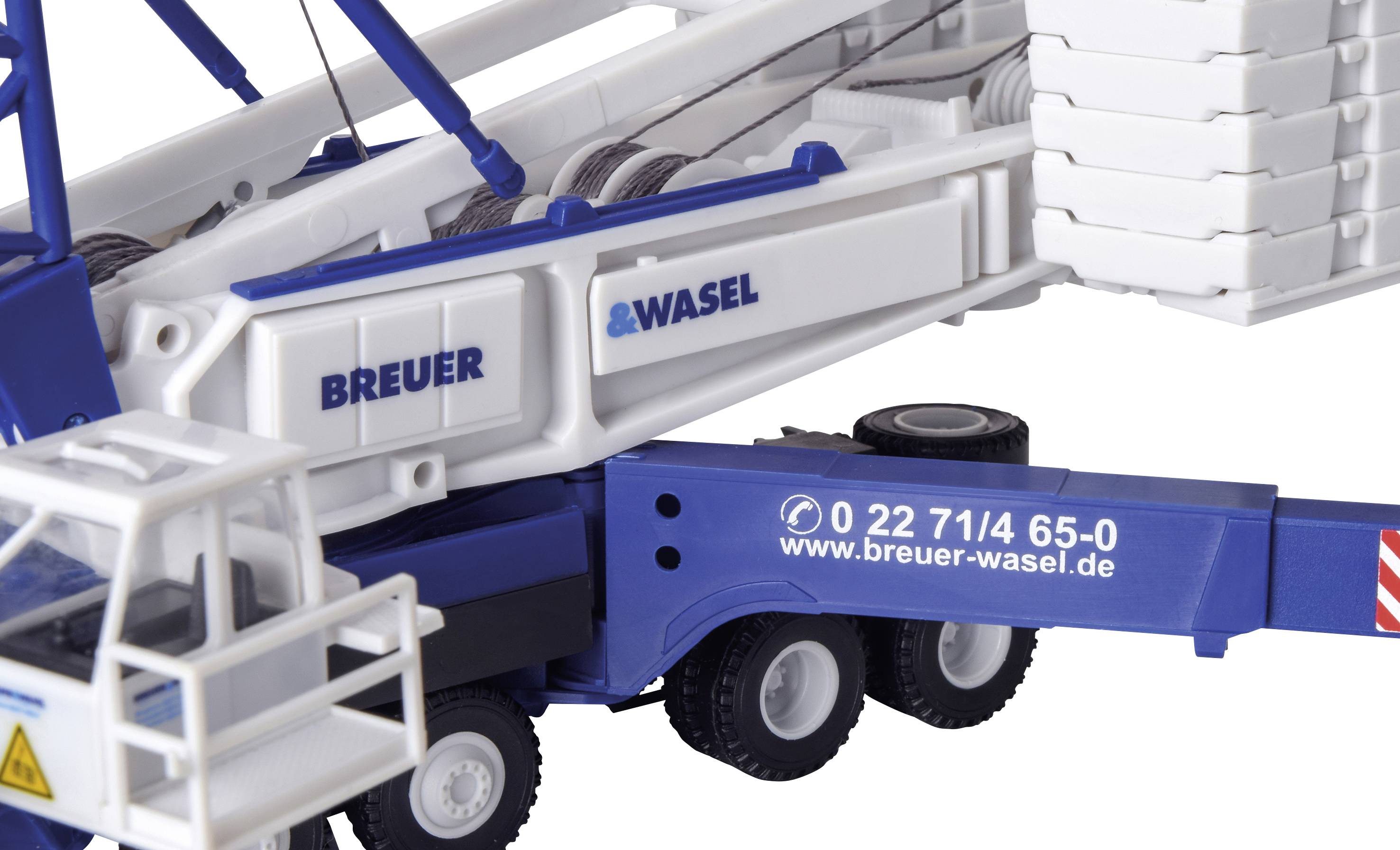 Model dźwigu budowlanego z nadrukami 'BREUER & WASEL' i numerem telefonu na boku.