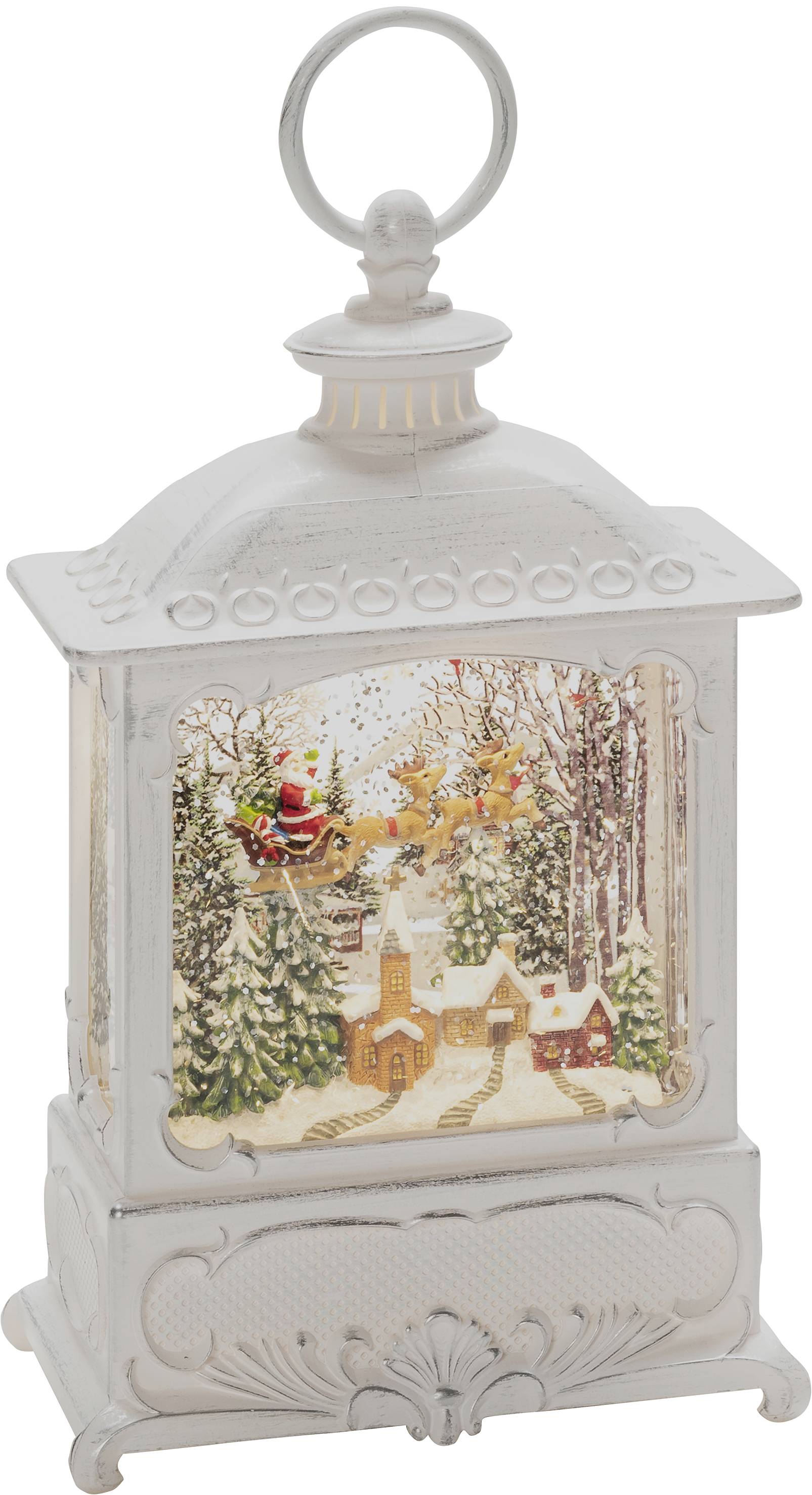 Biała śnieżna latarnia z zimową sceną: las, kościół, dwa domy, lecący Mikołaj z saniami i reniferami.