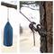 Uchwyt 'Rok Hardware Fence Post Tree Bracket' mocuje niebieską wiszącą torbę na drzewie. Zbliżenie na mechanizm linowy, podkreślające węzeł i układ napięcia.