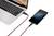 Smartfon jest podłączony do laptopa za pomocą czerwonego kabla i wyświetla stan naładowania na poziomie 85%.