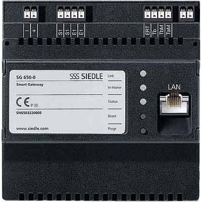 SBP Siedle SG 650-0 Smart Gateway. Czarne urządzenie z portem LAN i kilkoma zaciskami przyłączeniowymi u góry. Numer modelu i numer seryjny po lewej stronie na etykiecie.