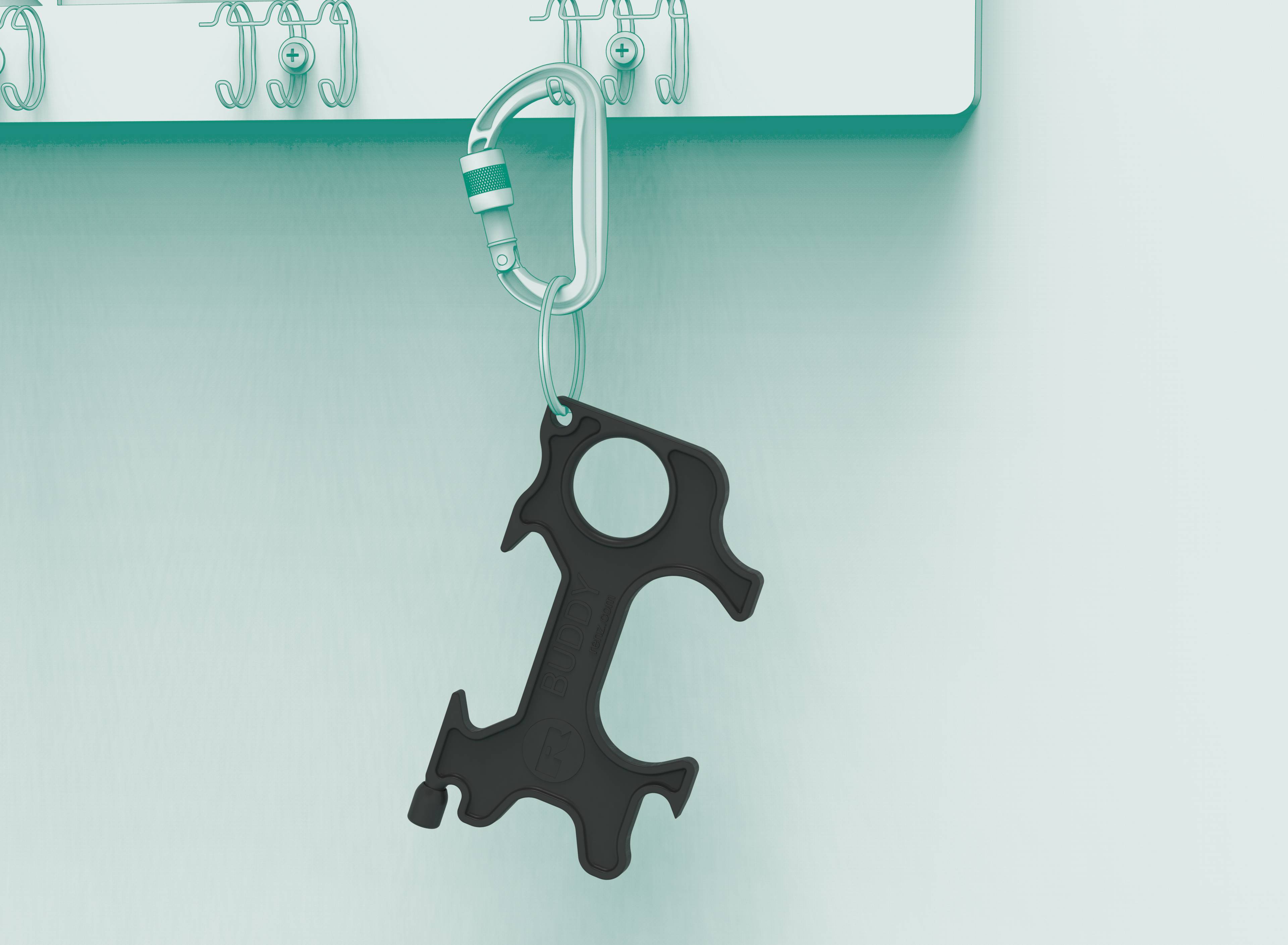 Czarny, wielofunkcyjny brelok wisi na haczyku na ścianie. W tle widać kolejne haczyki.