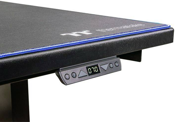 Biurko z regulacją wysokości z cyfrowym panelem sterowania, wyświetlającym aktualną wysokość 70 cm. Powierzchnia robocza z logo na brzegu.