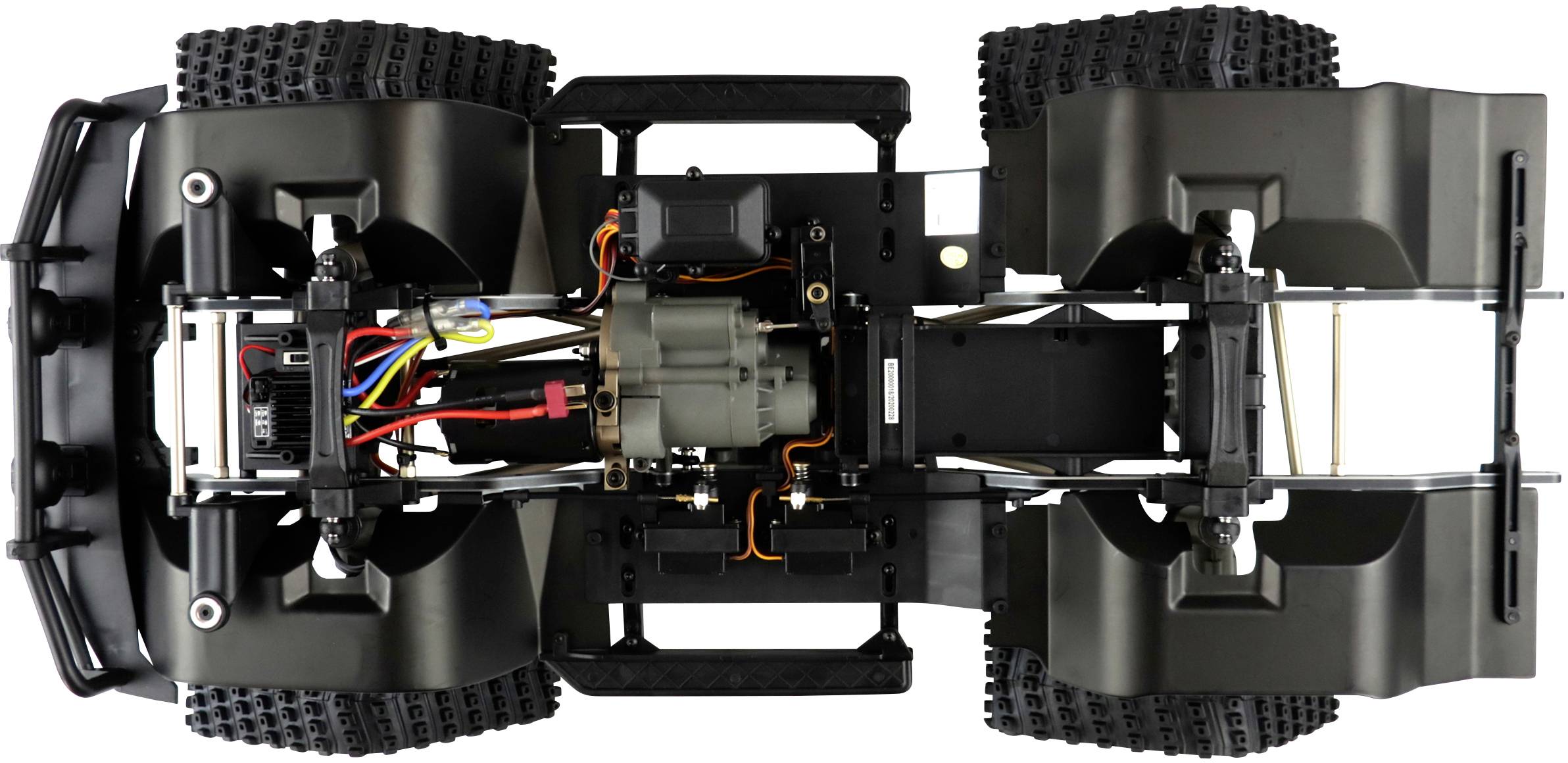 Widok od spodu podwozia modelu samochodu z widocznym silnikiem, elektroniką i grubobieżnymi oponami.