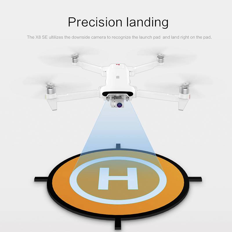 Dron z kamerą zawisa nad lądowiskiem z symbolem "H". Tekst powyżej opisuje tę czynność jako 'precyzyjne lądowanie'.
